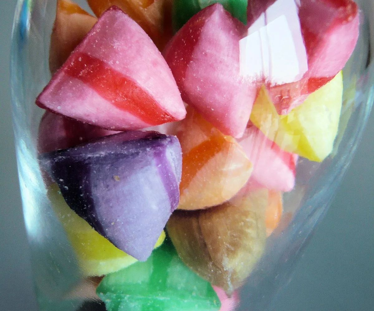 Berlingots de Carpentras rayés et colorés dans un bocal en verre, inspiration de forme pour un berlingot brodé