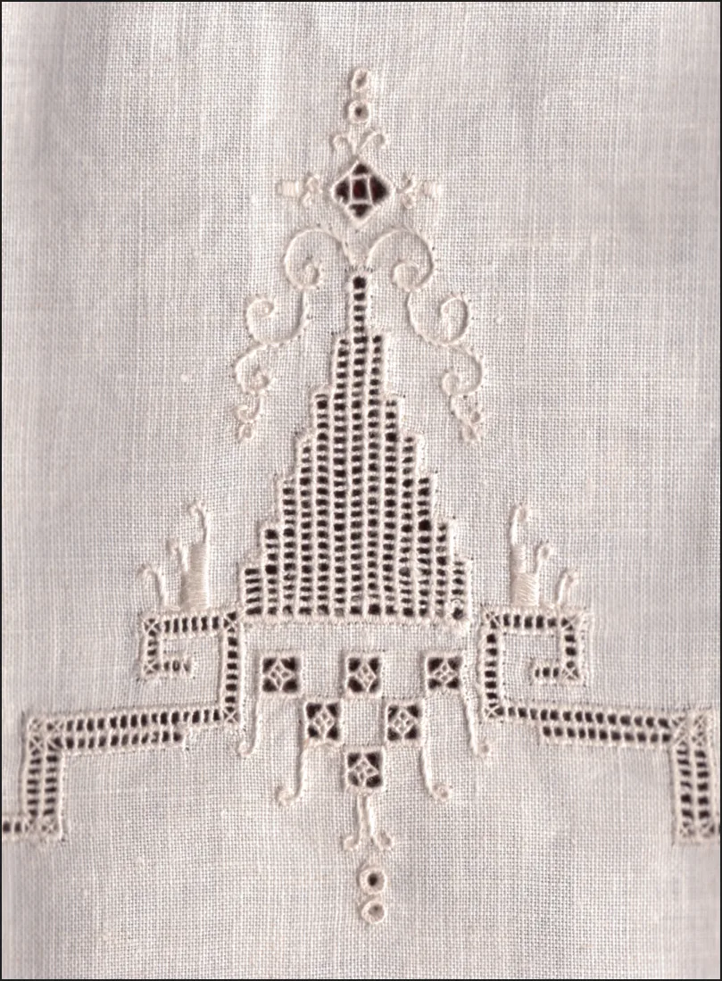 Détail d'une broderie blanche ajourée avec jours à fils tirés et point de feston, technique whitework sur lin blanc