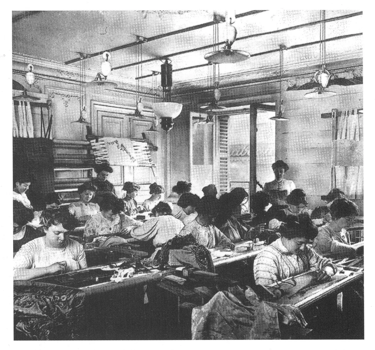 Atelier de couture de la maison Paquin vers 1910, ouvrières penchées sur leurs ouvrages autour de longues tables
