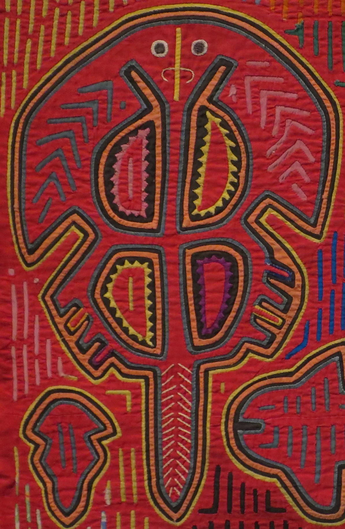 Détail macro d'un mola kuna montrant les fines découpes d'appliqué inversé ourlées à la main