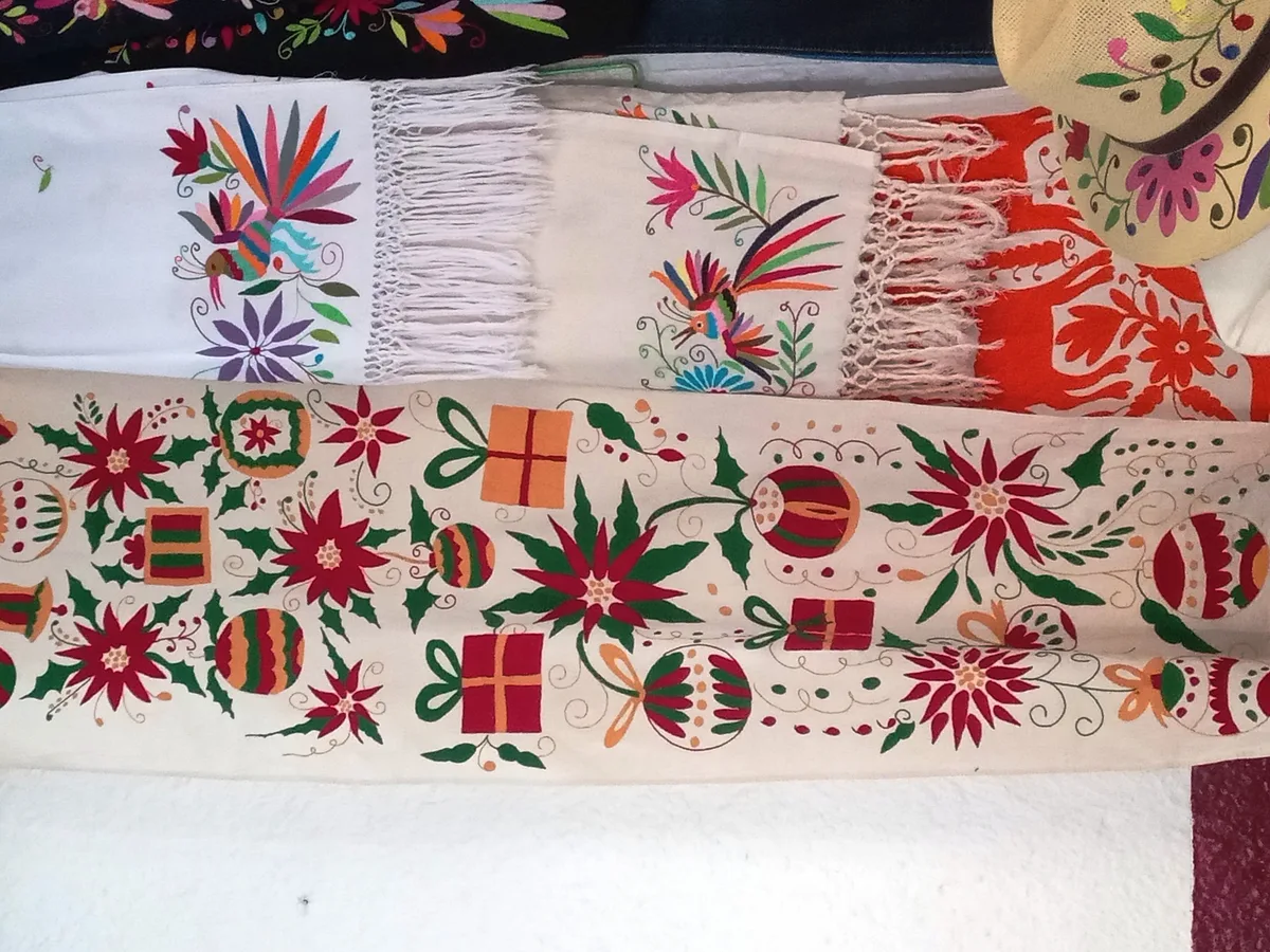 Broderies Otomi mexicaines sur châles et vêtements présentées dans un atelier artisanal