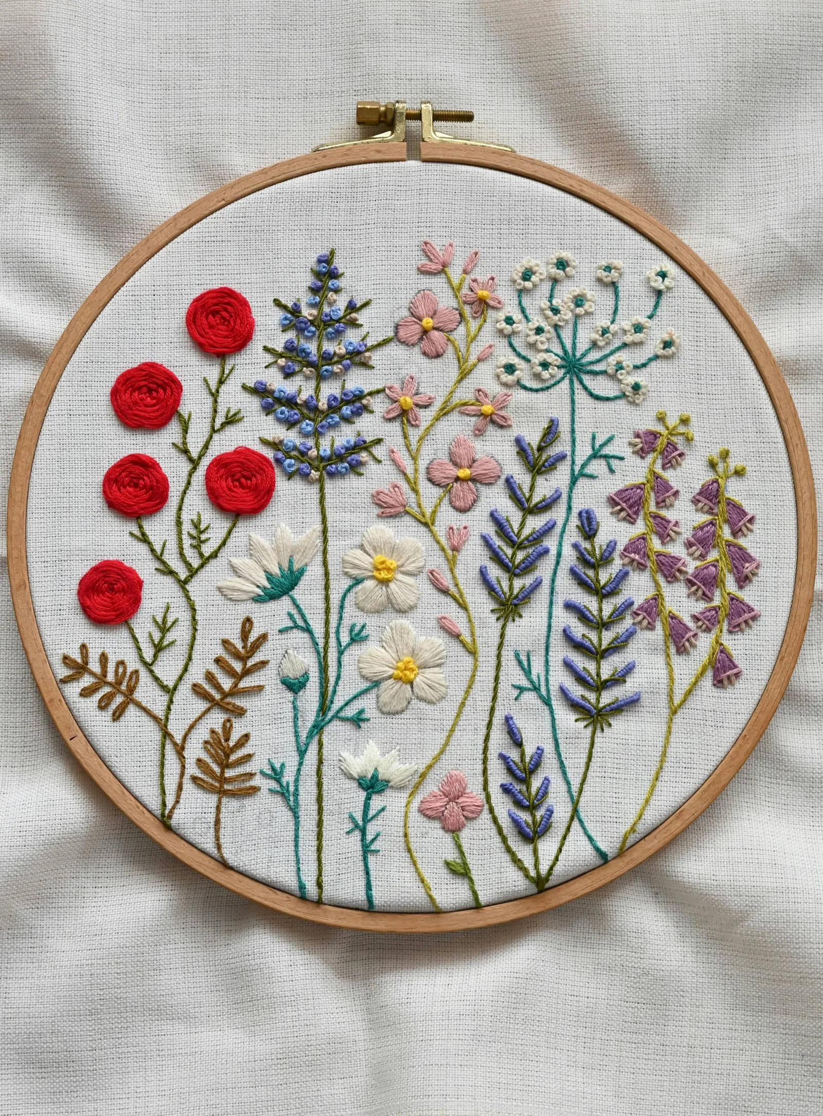 Broderie décorative accrochée au mur avec motifs floraux colorés, inspiration déco printanière brodée
