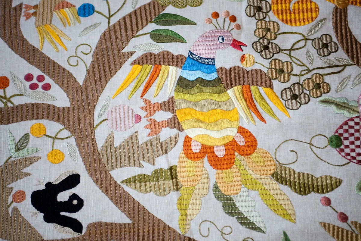 Détail macro d'un oiseau brodé de soie polychrome dans le style traditionnel de Castelo Branco