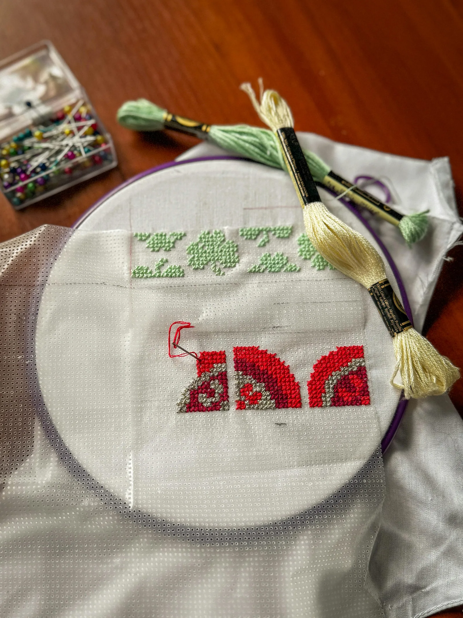 Monogramme brodé en fil doré et rouge sur toile, exemple de finition graphique pour un cadeau brodé homme