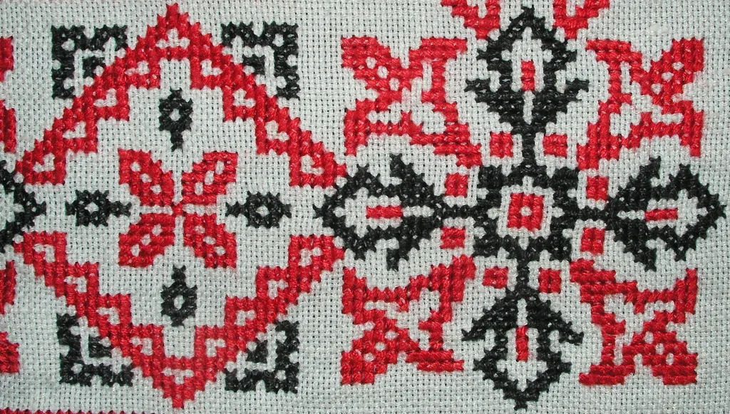 Motif géométrique brodé en point de croix sur toile Aïda avec fils rouge et noir