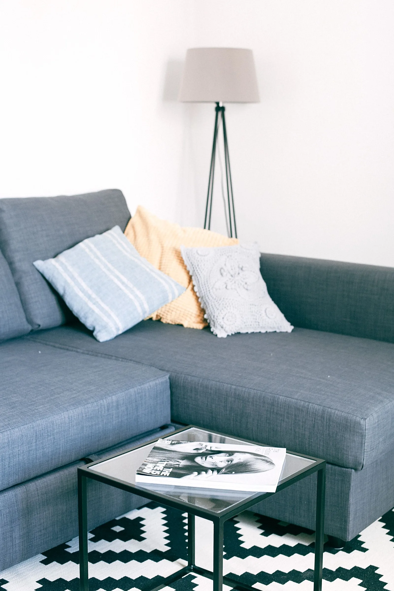 Canapé gris avec coussins textiles, coin de repos pour faire une pause pendant une séance de broderie