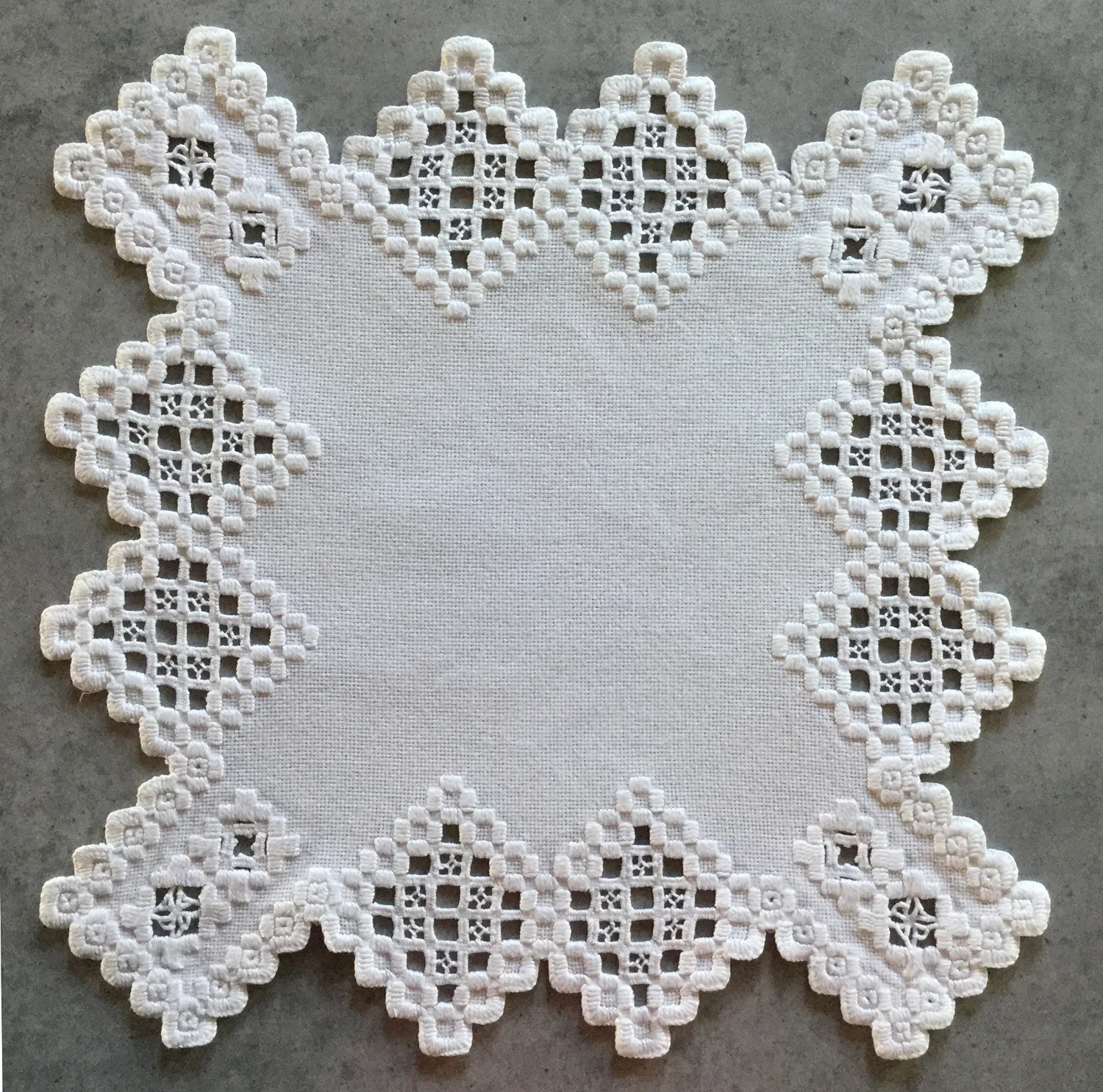 Carré Hardanger blanc avec bordure ajourée géométrique — exemple de nappe traditionnelle