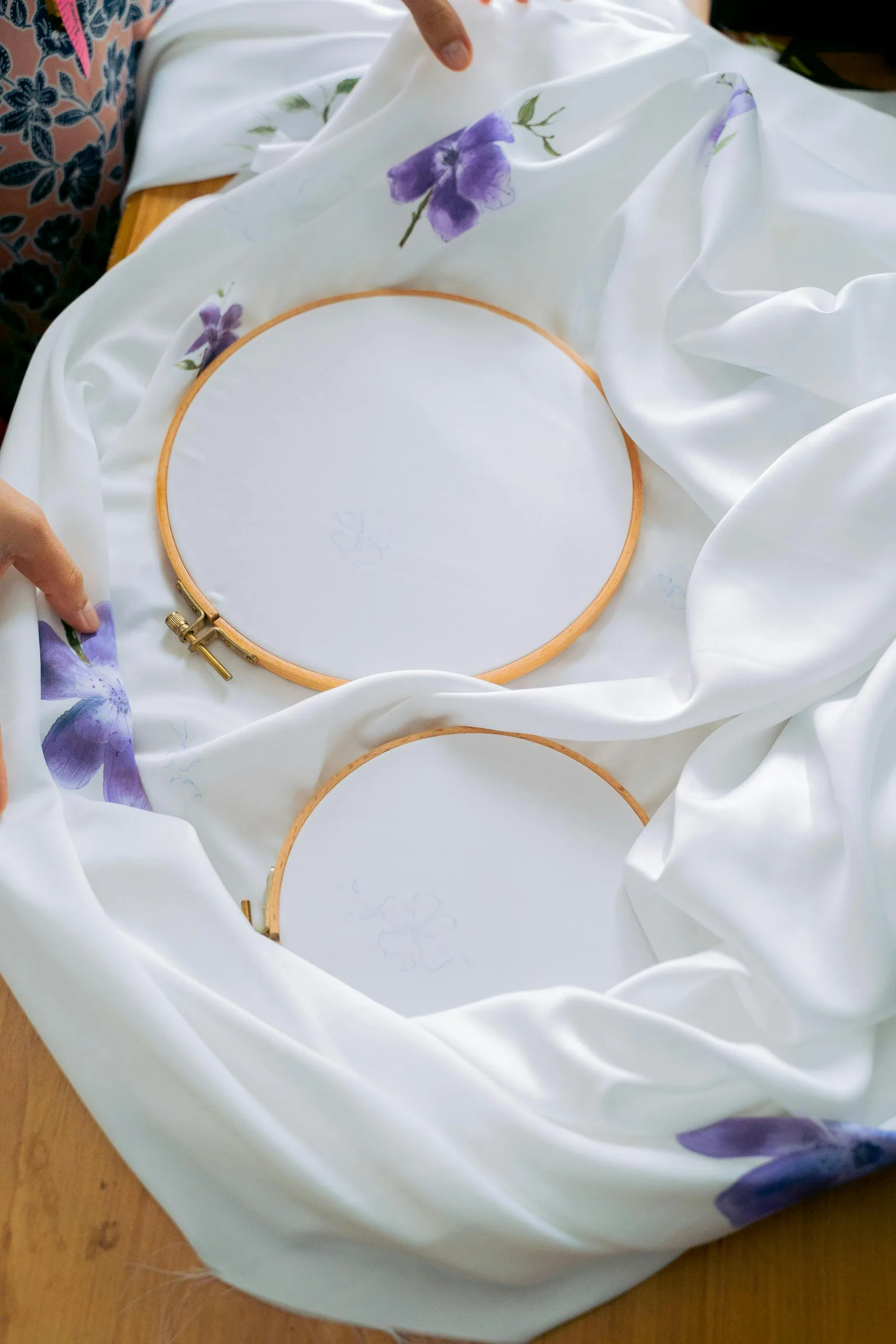 Cerceaux de broderie et tissu fleuri préparés pour un projet de cadeau de naissance personnalisé