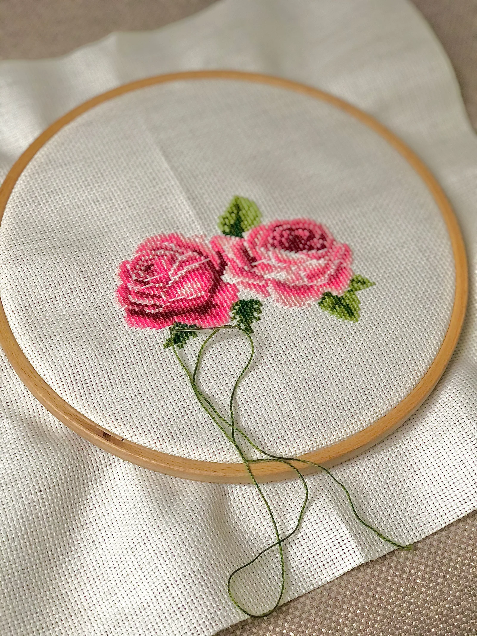 Broderie roses en point de croix dans un cerceau en bois, exemple de finition hoop art sur lin naturel