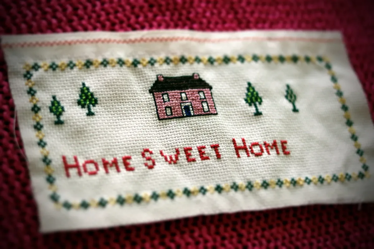 Sampler brodé traditionnel avec la phrase Home Sweet Home, base d'inspiration pour un détournement décalé