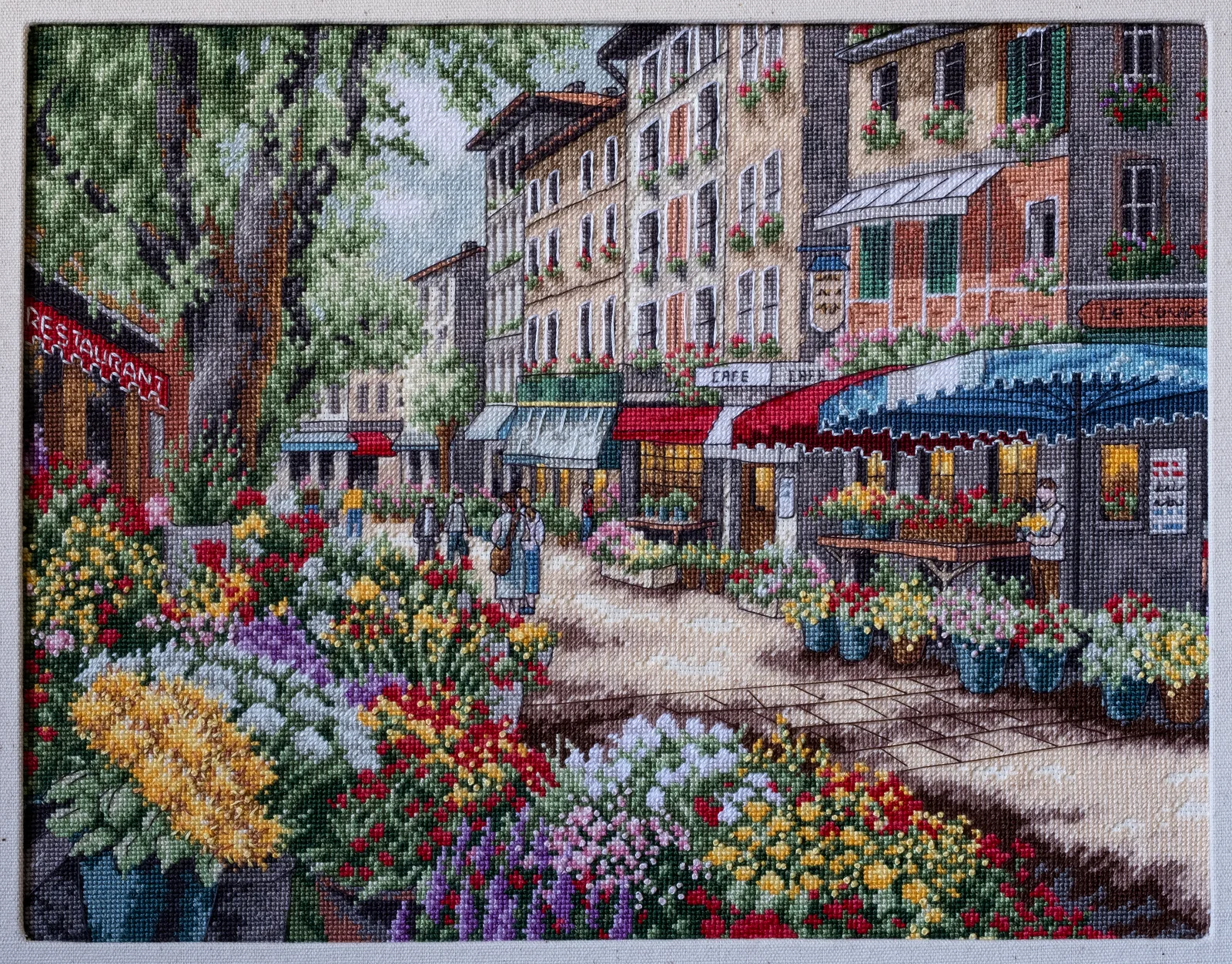 Petit motif brodé en rouge sur toile blanche, exemple de carte ou d'ornement réalisé sur toile perforée