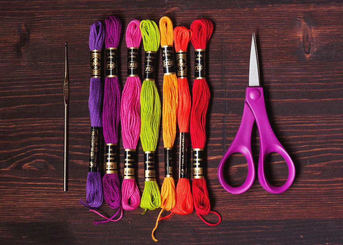 Fils à broder colorés et petits ciseaux fins pour broder sur toile perforée en point de croix