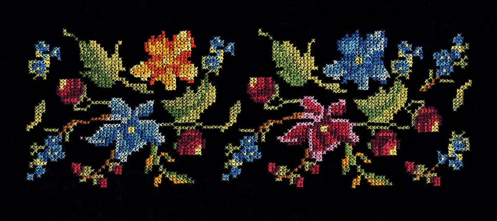Motif floral brodé en point de croix sur fond sombre, exemple de rendu sur toile perforée noire