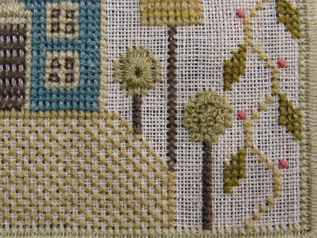 Sampler sur lin mêlant point de croix, œillet rond en relief, nœuds et points satinés comptés