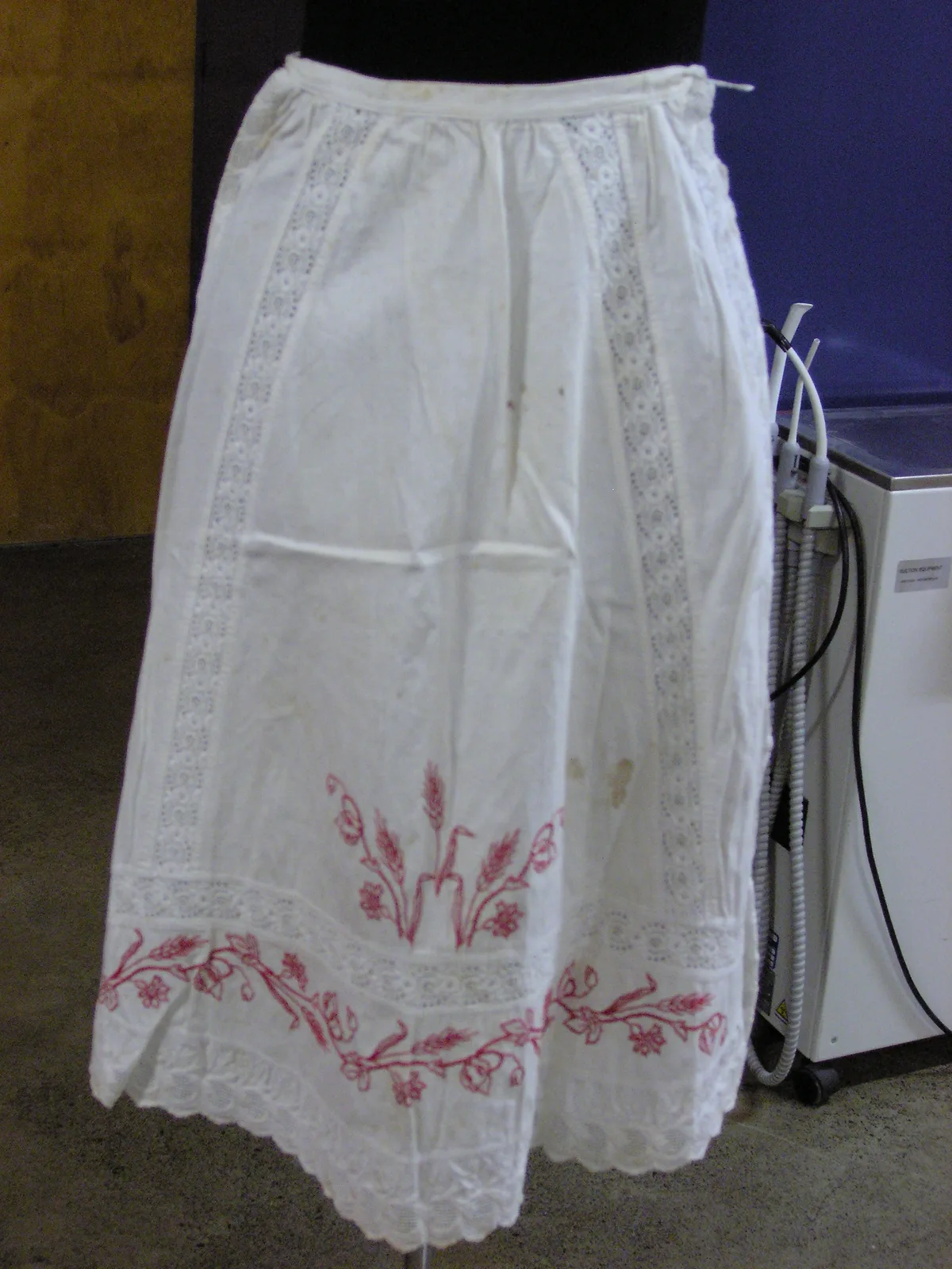 Tablier ancien en broderie redwork avec motif de blé et fleurs brodé en rouge sur coton blanc, pièce textile historique