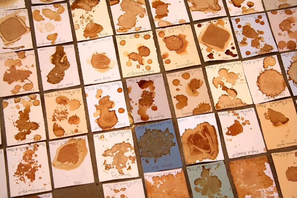 Série de cartes tachées au thé montrant différentes nuances et formes de taches brun clair